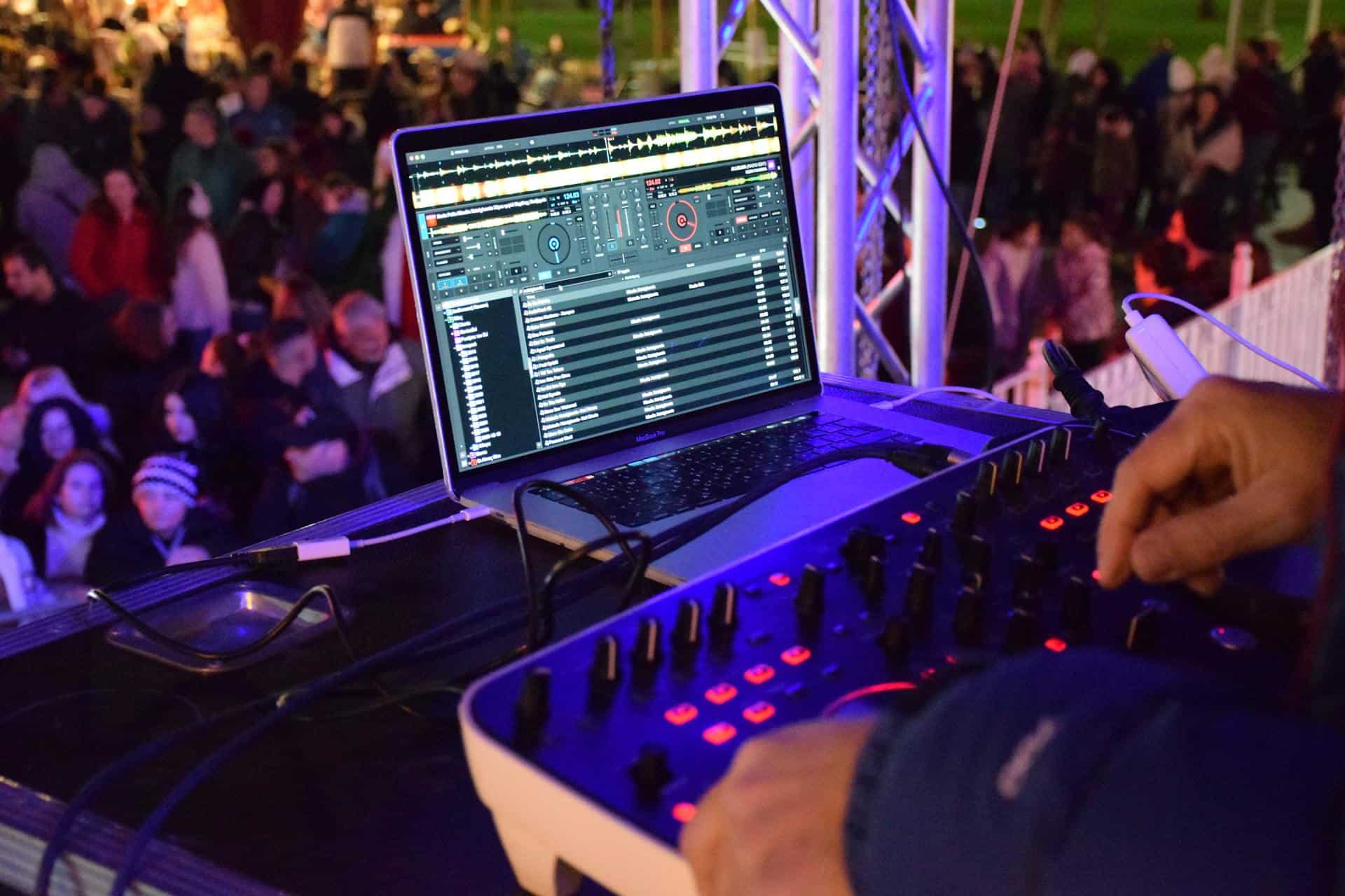Wedding DJ setup with mixing equipment at an outdoor event.